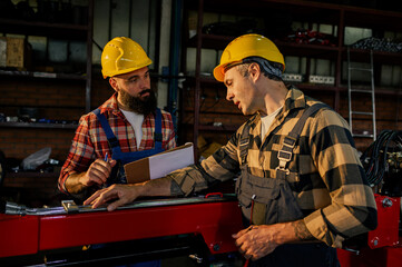 Coworkers developing a repair plan for a broken machine next to them.