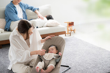 Obraz premium リビングで子育てをする4人アジア人（日本人）家族 見つめ合う赤ちゃんとお母さん