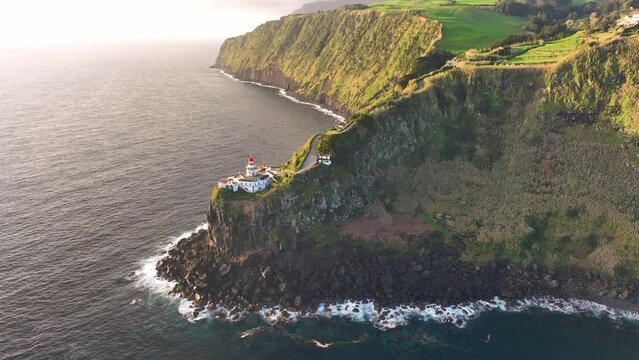 Aerial view of amazing Lighthouse Farol Ponta do Arnel in atlantic ocean, 4k footage. Sao Miguel, Azores, Portugal.