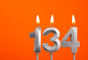 134 candle - Birthday celebration on orange background