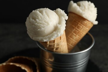 Ice cream scoops in wafer cones on gray table, closeup