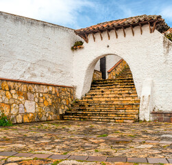 Stone steps leading to a rustic building in Guatavita, Cundinamarca, showcasing architectural beauty amidst natural surroundings