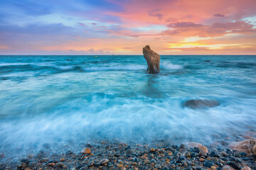 Landscape of rocky beach at sunset with ocean waves and pebbles on Co Thach beach, a famous beach...