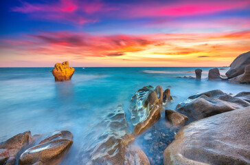 Landscape of rocky beach at sunset with ocean waves and pebbles on Co Thach beach, a famous beach...