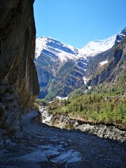 A majestic river winds its way through a scenic valley, enclosed by towering mountains that add to its grandeur.