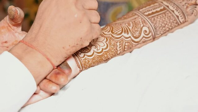 Full hand bridal mehndi design on beautiful Indian woman hands being designed Indian Wedding