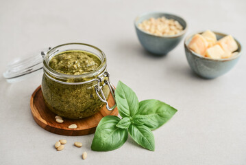 Sauce pesto in glass jar with fresh basil