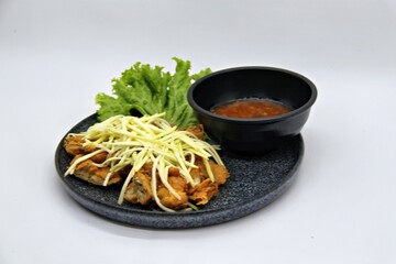 crispy chicken with mango sauce or Ayam Saus Mangga. The taste is savory spicy and a little sweet. Selective Focus