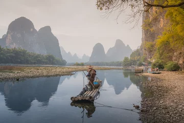 Papier Peint photo autocollant Guilin Cormorant fisherman and his bird on the Li River in Yangshuo, Guangxi, China.