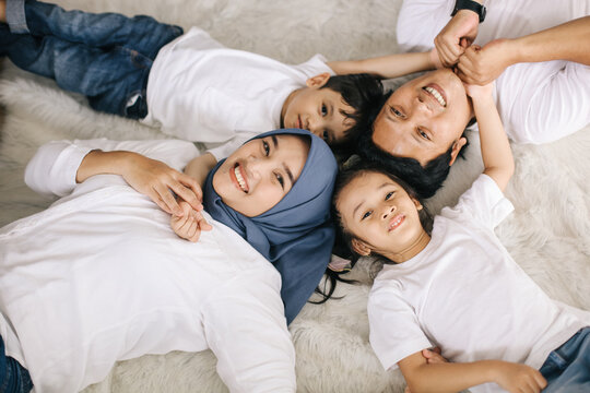 Top view portrait of happy Asian family lying on the floor at home