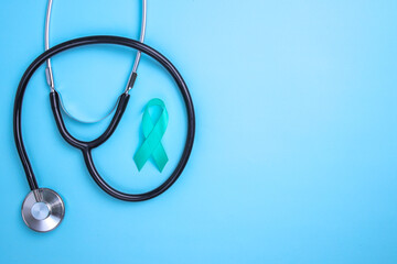 Teal awareness ribbon and stethoscope to support cancer survivor. Ovarian Cancer month, cervical...
