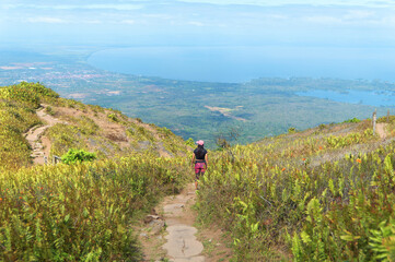 Woman standing on the mombacho volcano trail admiring the view of the scenery