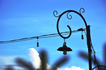The hanging garden lamp with a classic style pole that appears installed in a yard with a bright...