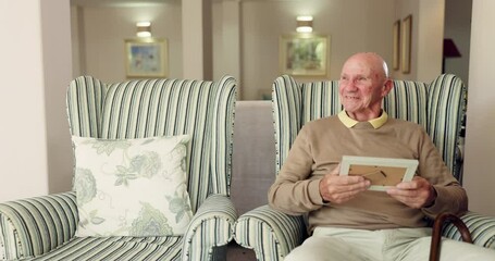Senior man, home and photo frame with happy memory, gratitude for life or missing a loved one in empty chair. Elderly person alone in retirement house with an album and smile, thinking or thoughtful