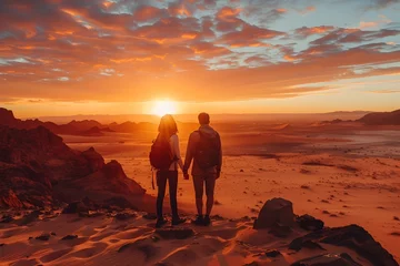 Tuinposter Couple Hiking in the Desert during Sunset © vanilnilnilla