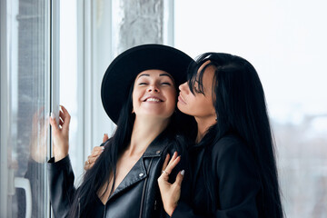 2 Beautiful sexy women posing against the window in black jackets - 752695786