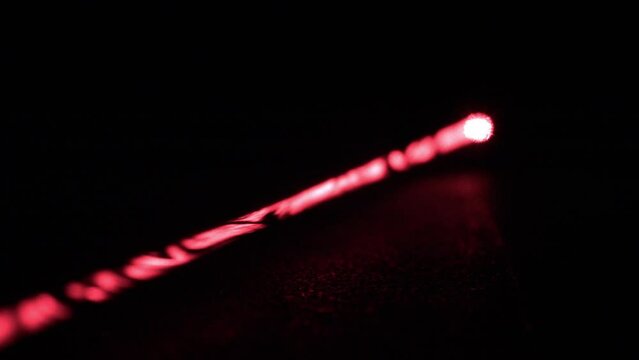 Long Red Laser Beam from Laser Pointer, Rack Focus, Black Background