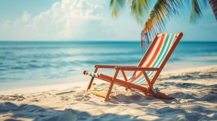 Empty striped beach chair facing the calm ocean, symbolizing peaceful solitude on a tropical beach. - obrazy, fototapety, plakaty