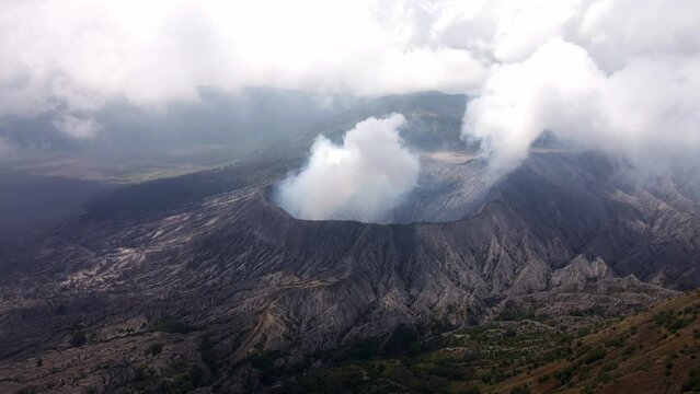 a mesmerizing view of Mount Bromo's volcanic eruption from above the clouds, aerial 4k drone footage