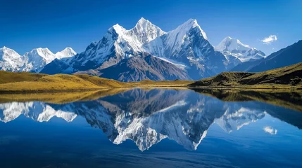 Photo sur Plexiglas Everest Snow-covered peaks reflecting in a serene lake, creating a breathtaking panorama under a clear, deep blue sky.