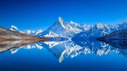 Foto op Plexiglas Snow-covered peaks reflecting in a serene lake, creating a breathtaking panorama under a clear, deep blue sky. © Marghoub