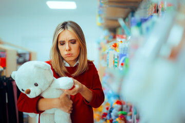 Shopping Woman Worried about a Toy Safety for her Baby. Curious mom checking product quality and safety standards on a teddy bear

 - obrazy, fototapety, plakaty