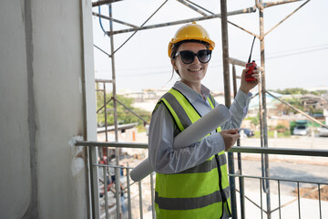 Portrait Caucasian engineer woman working with paper work and walkie talkie at construction site	