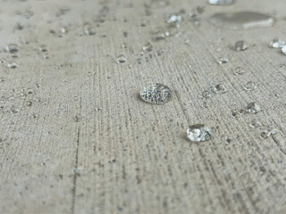Close-up shot of water droplets on a concrete slab