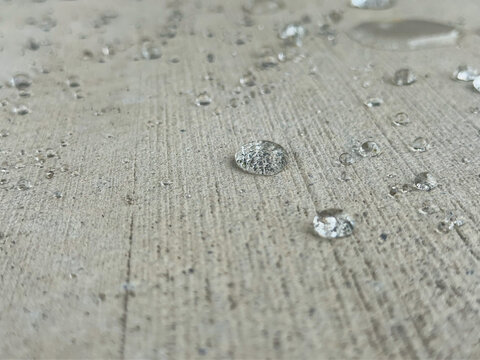 Close-up shot of water droplets on a concrete slab