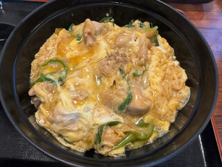 Japanese style omelet with pork and vegetables in a black bowl