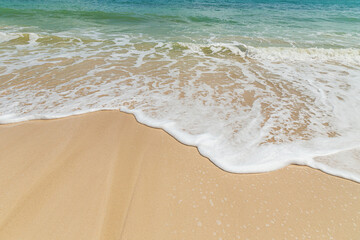 Beautiful white foam soft wave splashing on empty beach coastline summer holidays concept