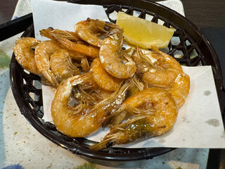 Fried prawns with lemon in a basket on the table