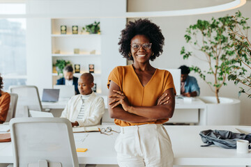 Confident black woman with afro hair smiling in a startup office