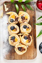 Asian sweet sushi pancake. Rolls with cream cheese berry and fruits.