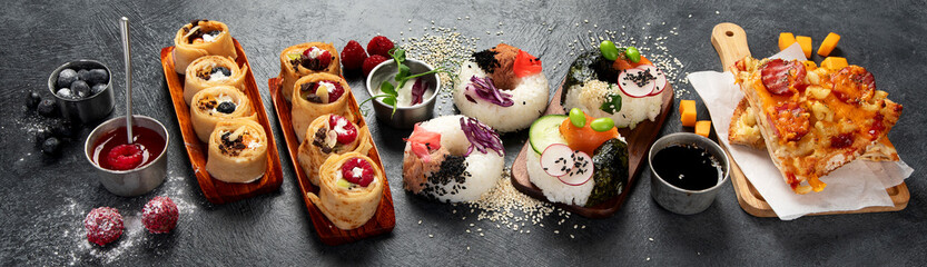 Hybrid trendy food on dark background. Sushi roll pancake, donut sushi, pizza with pasta