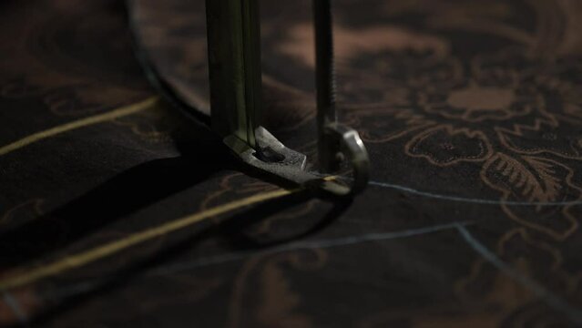 Old sewing machine. Close-up view of fabric cutting. fabric cutting process. Batik cloth cutting process