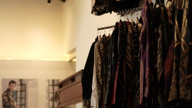 Batik clothes displayed in the shop. Batik clothes hanging. Clothes hanging in the shop