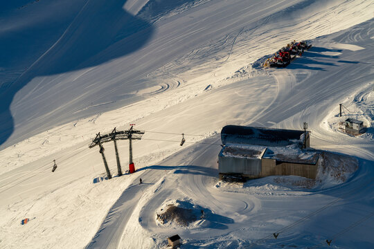 View to the Zugspitze glacier snow field during winter with the related cable car and background mountain range and the sunrise morning glow