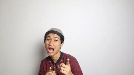 shocked asian muslim man gesturing pointing forward