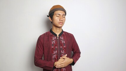 Obraz premium Asian Muslim man gesturing with stomach ache