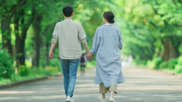 初夏の公園を歩くカップル