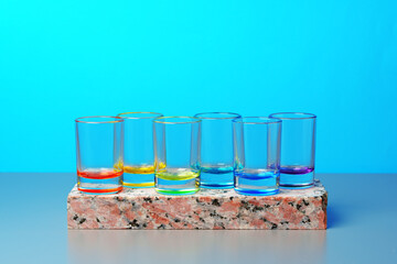 Set of colored vodka glasses on blue background