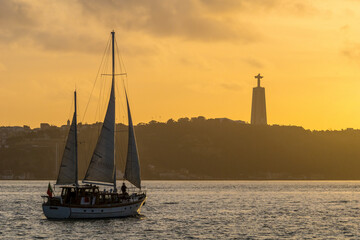 Tagus river with sailing boat at sunset in Lisbon, Portugal