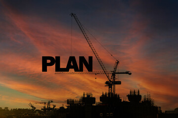 A construction site with the word PLAN written on a crane. The crane is a large, powerful machine...