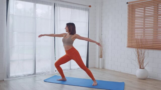 Asian young beautiful sportswoman doing yoga pilates workout at home. 