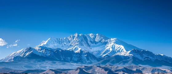 Obraz premium Panoramic view of pristine snow-covered mountain peaks under blue sky