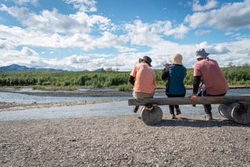 Tourists taking photos by the river using smartphones. Denali National Park and Preserve. Alaska....