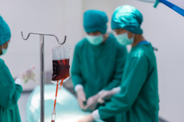 A bag of donated blood used during surgery. blood transfusion to a patient in the operating room.