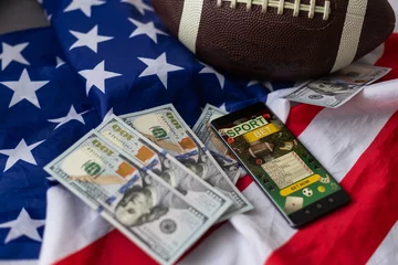 Foto op Plexiglas rugby ball and dollars with usa flag and smartphone bet © Angelov