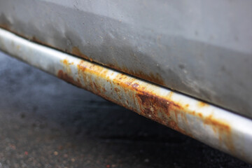 Rusty threshold of a grey old car